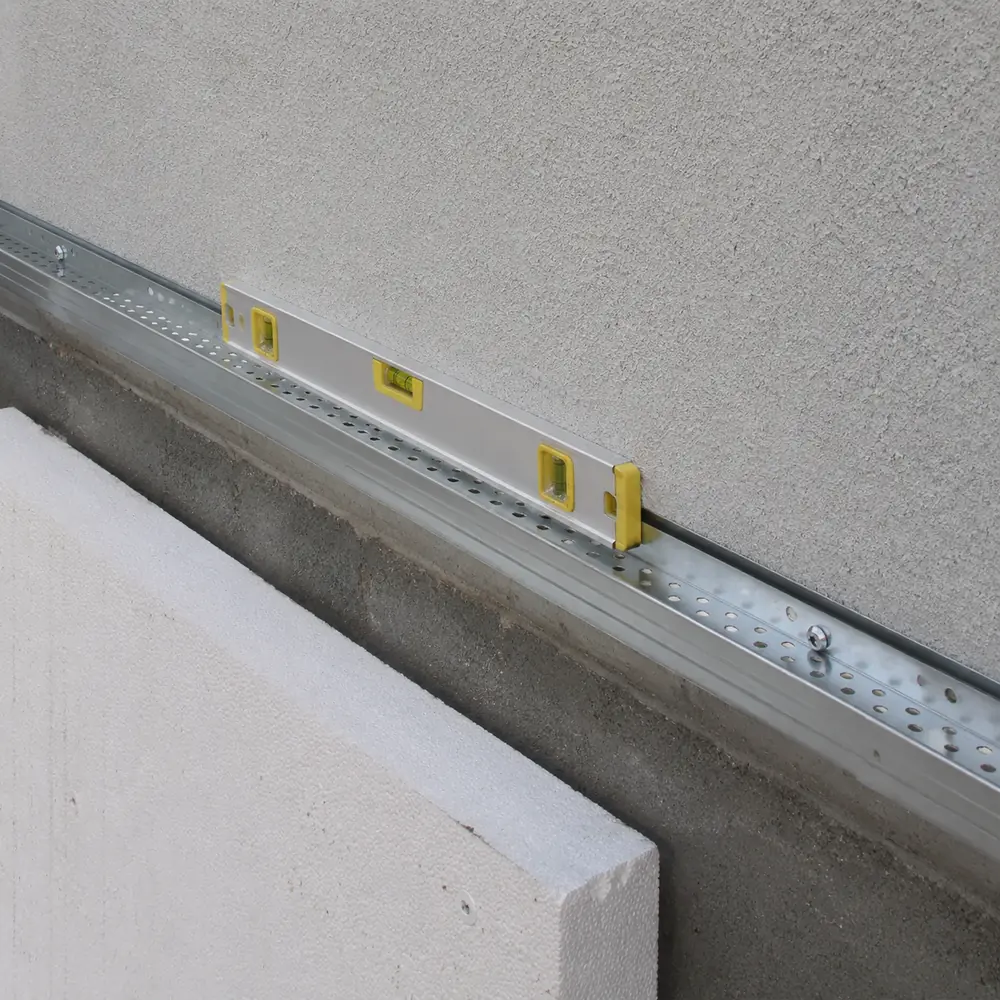 Base rail levelled along the bottom of a wall before boarding