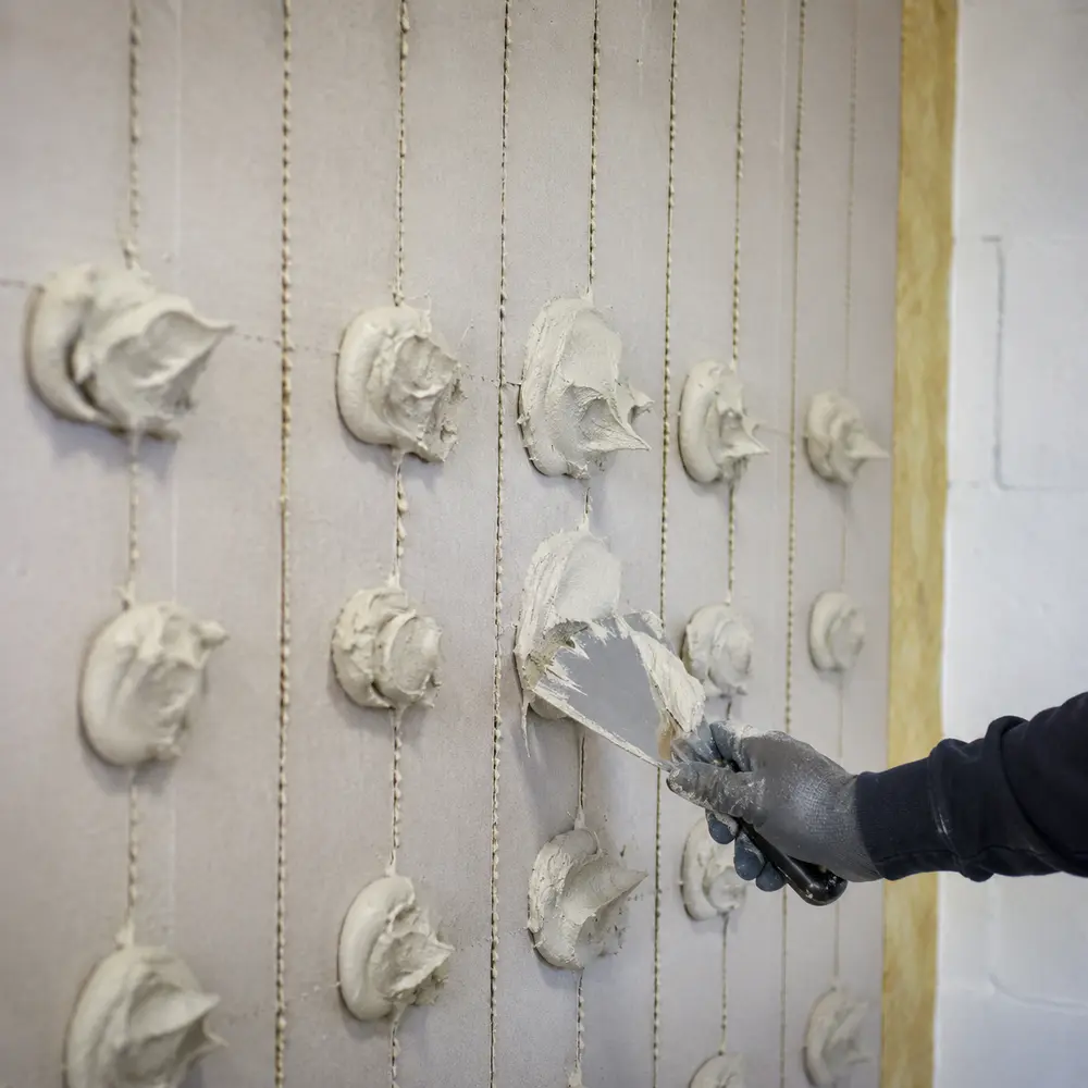Adhesive dabs applied to the back of an insulation board